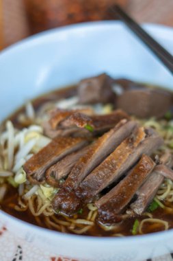 Kahverengi çorbada haşlanmış ördek ve haşlanmış yumurtalı şehriye Asya yemeği.