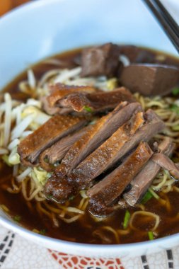 Kahverengi çorbada haşlanmış ördek ve haşlanmış yumurtalı şehriye Asya yemeği.