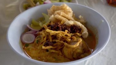 Khao Soi, Khao Soi Kai, Thai Noodles Khao Soi, ahşap zeminde baharatlı körili tavuk, Kuzey Tayland yemeği konsepti. (Lanna yemeği)
