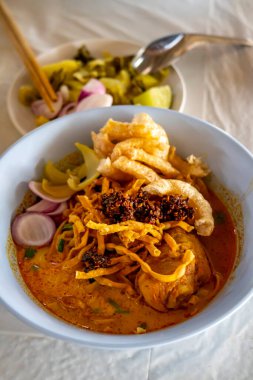 Khao Soi, Khao Soi Kai, Thai Noodles Khao Soi, ahşap zeminde baharatlı körili tavuk, Kuzey Tayland yemeği konsepti. (Lanna yemeği)