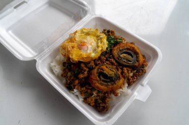 Baharatlı yüzyıllık yumurta ile karıştırılmış fesleğen buğulanmış pirinç ve acılı balık sosu ile servis edilmiş Tayland yemeği..