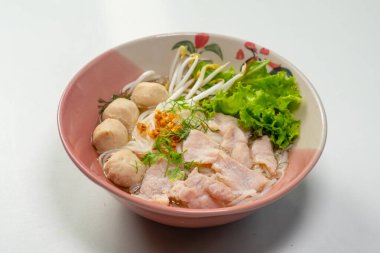 Elin yemek çubuğu tutarken, pilav çorbası içerken domuz eti, domuz eti topu ve sebze kasesinde Tayland eriştesi çorbası içerken.