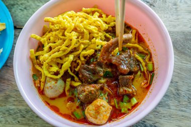 Khao Soi, Khao Soi Kai, Thai Noodles Khao Soi, ahşap zeminde baharatlı körili tavuk, Kuzey Tayland yemeği konsepti. (Lanna yemeği)