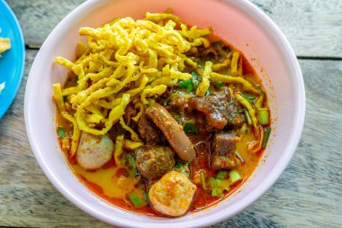 Khao Soi, Khao Soi Kai, Thai Noodles Khao Soi, ahşap zeminde baharatlı körili tavuk, Kuzey Tayland yemeği konsepti. (Lanna yemeği)