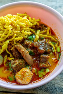 Khao Soi, Khao Soi Kai, Thai Noodles Khao Soi, ahşap zeminde baharatlı körili tavuk, Kuzey Tayland yemeği konsepti. (Lanna yemeği)