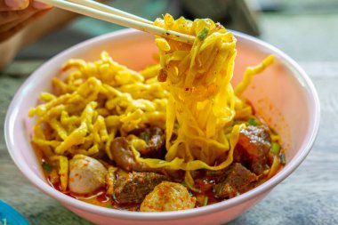 Khao Soi, Khao Soi Kai, Thai Noodles Khao Soi, ahşap zeminde baharatlı körili tavuk, Kuzey Tayland yemeği konsepti. (Lanna yemeği)