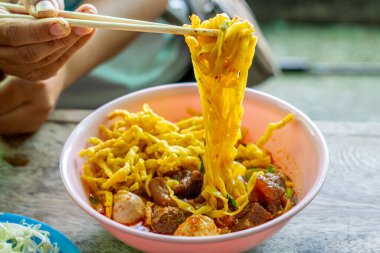 Khao Soi, Khao Soi Kai, Thai Noodles Khao Soi, ahşap zeminde baharatlı körili tavuk, Kuzey Tayland yemeği konsepti. (Lanna yemeği)