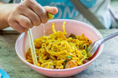 Khao Soi, Khao Soi Kai, Thai Noodles Khao Soi, ahşap zeminde baharatlı körili tavuk, Kuzey Tayland yemeği konsepti. (Lanna yemeği)