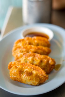 Beyaz arka planda bol yağda kızartılmış gyoza.