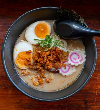 Erişte, domuz eti, tavuk, haşlanmış yumurta ve deniz yosunu salatasıyla servis edilen sebze tabakları.