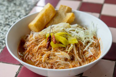 Khanom Jeen Yam; balık biberli erişte. Vermicelli 'nin geleneksel Tayland yemekleri beyaz arka planda izole edilmiş sebzelerle servis edilir..