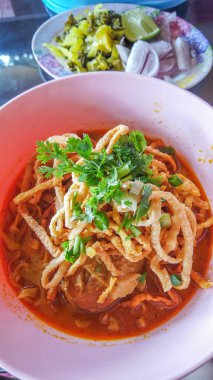Khao Soi, Khao Soi Kai, Thai Noodles Khao Soi, ahşap zeminde baharatlı körili tavuk, Kuzey Tayland yemeği konsepti. (Lanna yemeği)