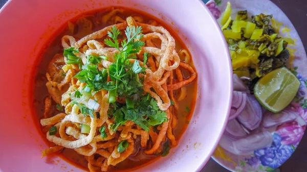 Khao Soi, Khao Soi Kai, Thai Noodles Khao Soi, ahşap zeminde baharatlı körili tavuk, Kuzey Tayland yemeği konsepti. (Lanna yemeği)