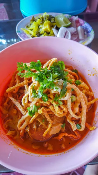 Khao Soi, Khao Soi Kai, Thai Noodles Khao Soi, ahşap zeminde baharatlı körili tavuk, Kuzey Tayland yemeği konsepti. (Lanna yemeği)