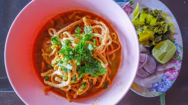 Khao Soi, Khao Soi Kai, Thai Noodles Khao Soi, ahşap zeminde baharatlı körili tavuk, Kuzey Tayland yemeği konsepti. (Lanna yemeği)