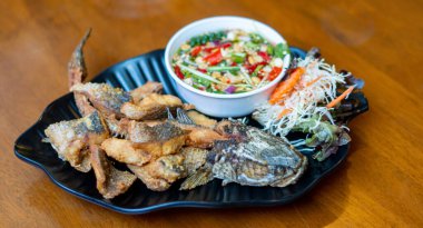 Pla Kapong Tod Nam Pla - Balık soslu kızarmış deniz pirinci, baharatlı mango salatası ve deniz ürünleri sosuyla servis