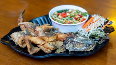 Pla Kapong Tod Nam Pla - Balık soslu kızarmış deniz pirinci, baharatlı mango salatası ve deniz ürünleri sosuyla servis