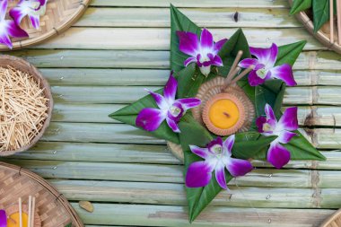 Krathong, yüzen kısımdan yapılmış el yapımı yüzen mum yeşil yapraklı çiçekler ve Tayland 'daki Loy Krathong festivali için birçok yaratıcı malzeme ile dekore edilmiş.