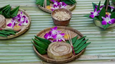 Krathong, yüzen kısımdan yapılmış el yapımı yüzen mum yeşil yapraklı çiçekler ve Tayland 'daki Loy Krathong festivali için birçok yaratıcı malzeme ile dekore edilmiş.