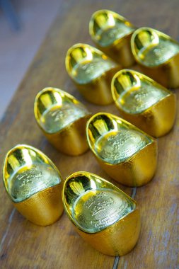 Ayakkabı şeklinde altın külçeler (Yuan Bao), Çin 20. para birimi. Çin Yeni Yılı için uğurlu sembol kavramı. Hafifçe odaklanmış ve yakın çekim. Doğal ışıkla vurulmuş.