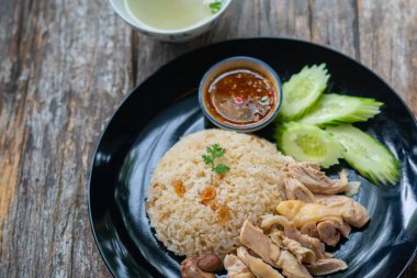 Haşlanmış pirinç ve tavuk, çorba ve çeşitli sosla servis edilir..