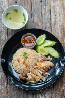 Haşlanmış pirinç ve tavuk, çorba ve çeşitli sosla servis edilir..