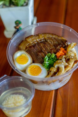 Bir kase pirinç, üstüne de domuz eti ve haşlanmış yumurta.