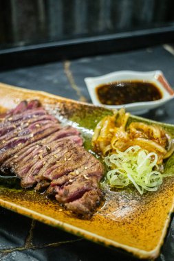 Biftek ızgarasında ince dilimler halinde et kızarmaya ve cızırdamaya başlıyor, otantik Japon restoranı.
