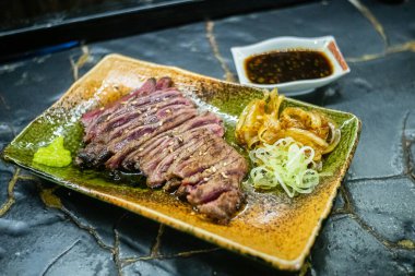 Biftek ızgarasında ince dilimler halinde et kızarmaya ve cızırdamaya başlıyor, otantik Japon restoranı.