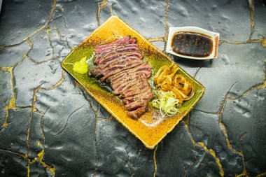 Biftek ızgarasında ince dilimler halinde et kızarmaya ve cızırdamaya başlıyor, otantik Japon restoranı.