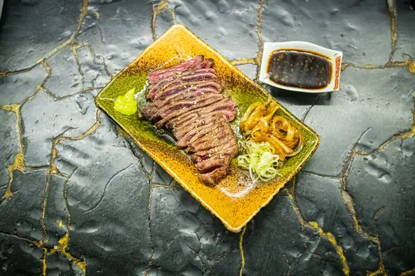 Biftek ızgarasında ince dilimler halinde et kızarmaya ve cızırdamaya başlıyor, otantik Japon restoranı.
