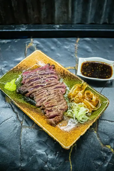 Biftek ızgarasında ince dilimler halinde et kızarmaya ve cızırdamaya başlıyor, otantik Japon restoranı.