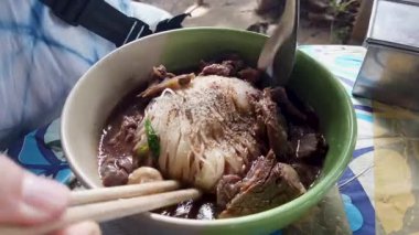 Pirinç Erişteli Biftek Çorbası ile Biftek haşlanmış Sarımsak ve Kokulu Ot Taze soğan ve Basil Thai otları süslüyor. Thai Bot Eriştesi Biçimi üst görünüm