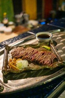 Biftek ızgarasında ince dilimler halinde et kızarmaya ve cızırdamaya başlıyor, otantik Japon restoranı.