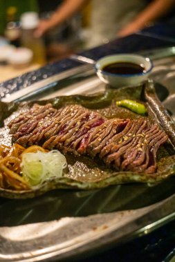 Biftek ızgarasında ince dilimler halinde et kızarmaya ve cızırdamaya başlıyor, otantik Japon restoranı.