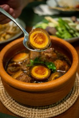 Üst manzara haşlanmış yumurta ve siyah tatlı soslu domuz eti geleneksel ve popüler Tayland yemekleri.