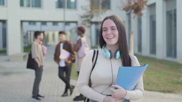 Üniversite Kampüsünde Arkadaşları Arkada Konuşurken Öğrenci Kız Kameraya Bakıyor — Stok video