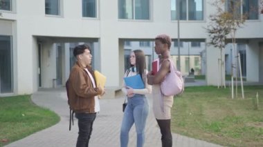 Üniversite kampüsünde bir grup üniversite öğrencisi sınavlar hakkında konuşuyor.
