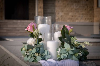 Güzel beyaz mum ve çiçek süslemelerinin ayrıntıları. Düğün masasında kurdeleler var.