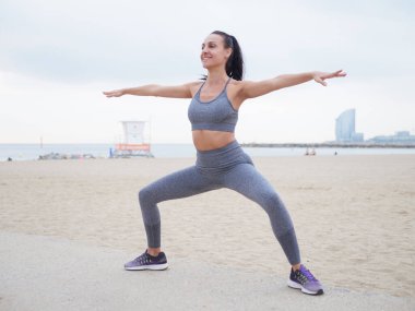 Playa de la Barceloneta 'da esneme hareketleri yapan genç bir kadın.. 