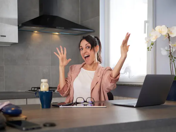 オフィスで働いて成功を祝うラップトップコンピュータを持つ幸せな笑顔の若い女性 ストックフォト