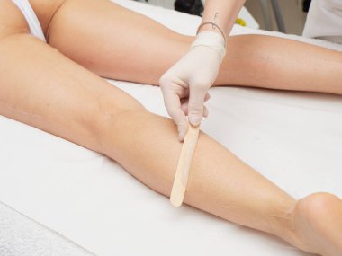 Genç kadınların saçlarını kesmeden önce ağda yapan bir güzellik uzmanı.