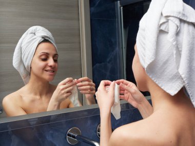 Kadın yüz maskesini banyoya koymuş.