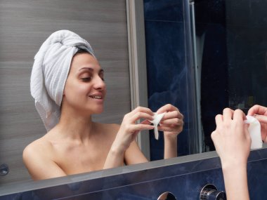 Kadın yüz maskesini banyoya koymuş.