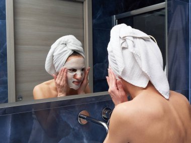 Kadın yüz maskesini banyoya koymuş.