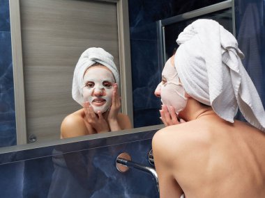 Kadın yüz maskesini banyoya koymuş.