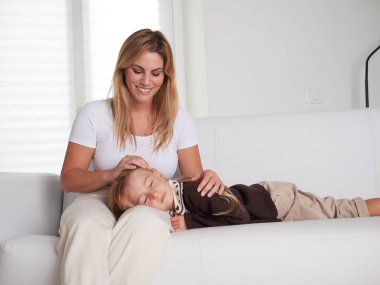 Anne ve kızı oturma odasında kanepede oturan