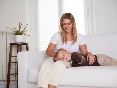 Anne ve kızı oturma odasında kanepede oturan