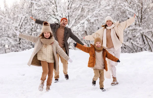 冬の公園で両親と屋外で楽しい時間を過ごし 腕を伸ばして笑い 雪の天気を楽しんで 家族は新年とクリスマス休暇中に屋外活動を楽しむ — ストック写真