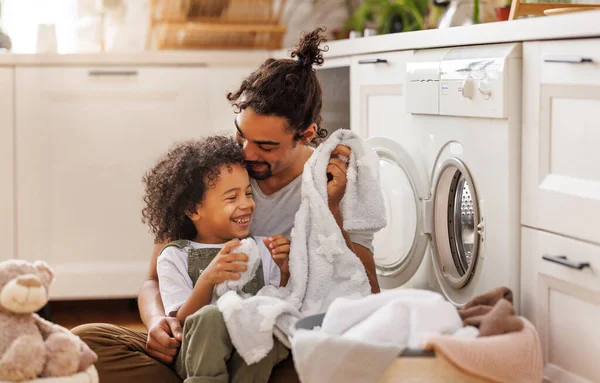 Fröhlicher Schwarzer Junge Lächelt Papa Und Hilft Vater Bei Wäsche — Stockfoto